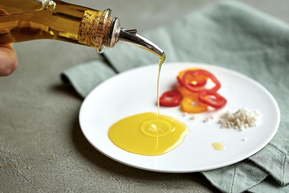 Olive oil drizzle from Bottle onto plate